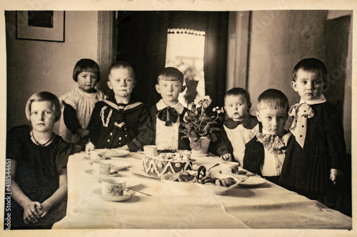 Germany - CIRCA 1920s: Group photo of seven small kids girls and boys on children birthday party. Vintage archive Art Deco era photography