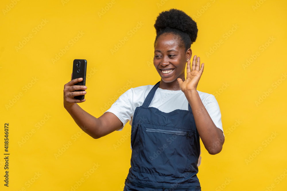 female african chef waving to someone on a video call female african chef waving to someone on a video call