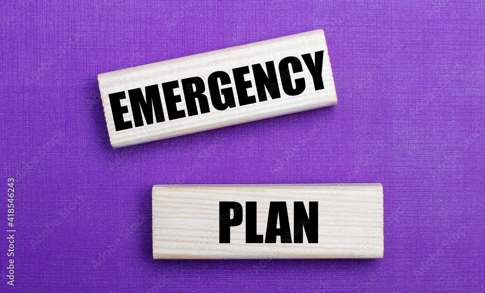 On a lilac bright background, light wooden blocks with the text EMERGENCY PLAN