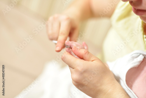 selective focus The mother cuts the child's toenails on the arm with baby safe scissors. Close-up. Self care authentic concept. Mother care is most important for baby healthy life lifestyle
