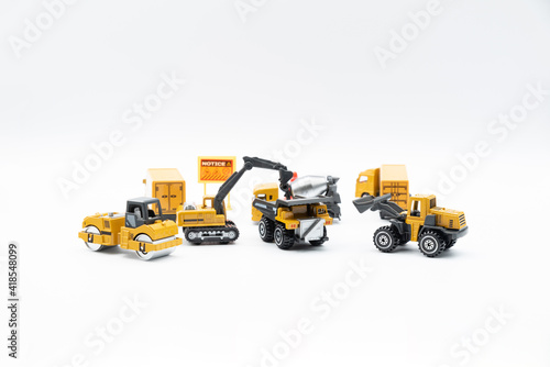 Construction site work vehicles on white background with copy space.