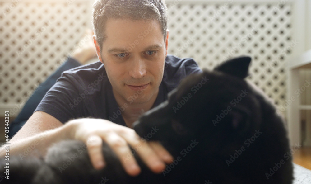 Obraz premium Man playing with his Schipperke dog.