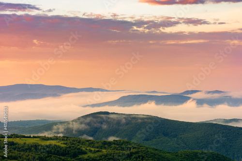 glowing fog in the rural valley at dawn. beautiful mountain landscape in springtime. view from the hill