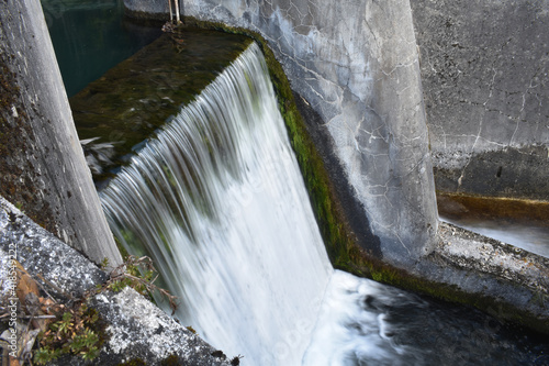 Wasserfall an Wehr, Kleinkraftwerk mit Wassereffekt und grauer Betonkonstruktion