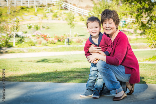 Happy Chinese Grandmother Having Fun with Her Mixed Race Grandson Outside