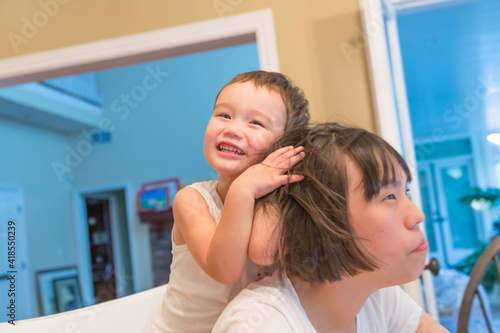 Happy Mixed Race Chinese and Caucasian Boy Having Fun with Chinese Mother Inside House