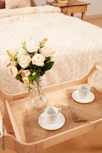 interior, tray with coffee cups, flowers in a vase. Breakfast.