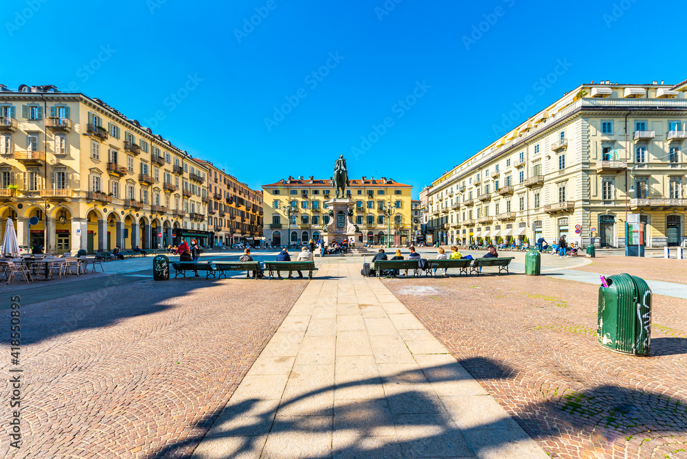 Turin, Italy. March 1st, 2021. Piazza Gianbattista Bodoni with the Equestrian statue of General Alfonso Ferrero della Marmora in a March sunny day with young people sitting on the benches.
