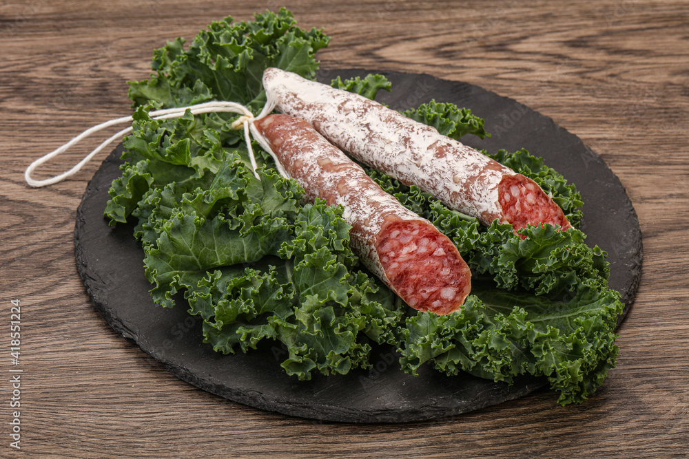 Spanish Fuet sausage with salad leaves Spanish Fuet sausage with salad leaves