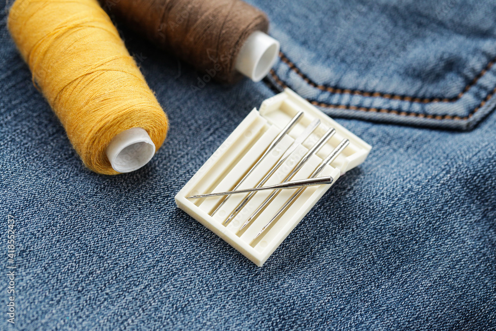 Needle and Thread on jeans texture. Denim fabric. Close up Needle and Thread on jeans texture. Denim fabric. Close up