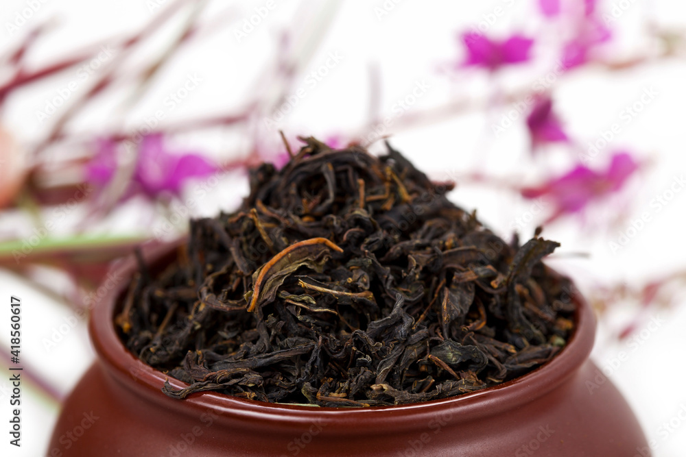 Clay pot with dry tea and blooming Chamerion angustifolium (common names: fireweed, great willowherb, rosebay willowherb) plant on a white background. Clay pot with dry tea and blooming Chamerion angustifolium (common names: fireweed, great willowherb, rosebay willowherb) plant on a white background.