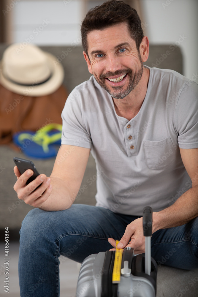 happy man traveler sitting with suitcase happy man traveler sitting with suitcase