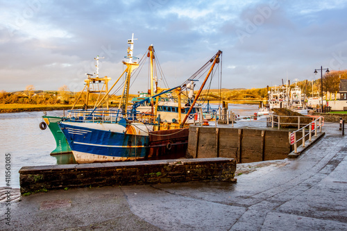 Fishing trawlers moored at Kirkcudbright harbour on the River Dee at sunset photo