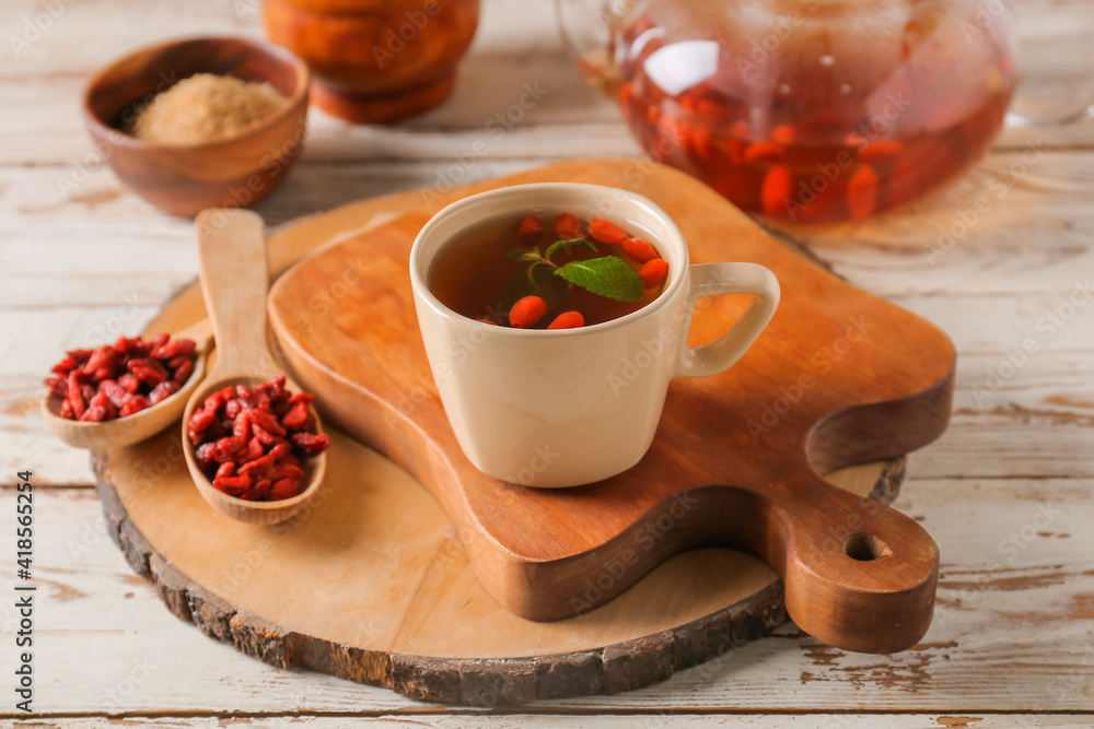 Cup with goji tea on wooden background Cup with goji tea on wooden background