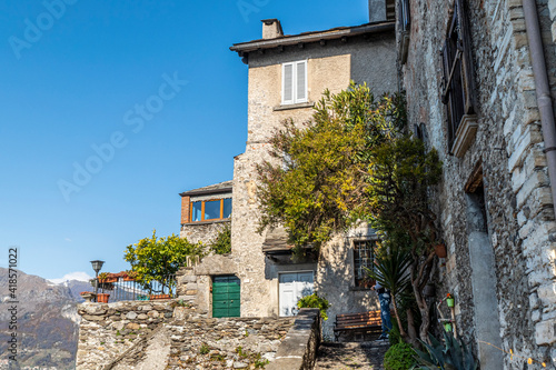 Corenno Plinio with stone houses, plants and flowers photo