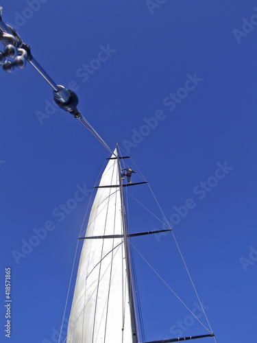 sailor at the top of the mast of sailing yacht VOLVO 60