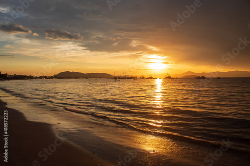 Sunset on a tropical beach with pirate boats in the background  located on the beach of Cachoeira do Bom Jesus  Canasvieras  Ponta das Canas  Florianopolis  Santa Catarina  Florian  polis  Brazil