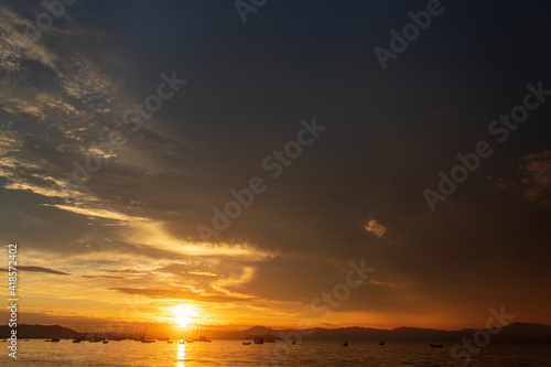 Sunset and dark clouds on a tropical beach with boats in the background  located on the beach of Cachoeira do Bom Jesus  Canasvieras  Ponta das Canas  Florian  polis  Santa Catarina  Brazil