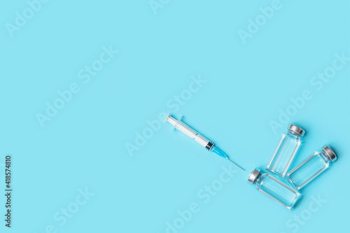 syringes and ampoules with vaccinations on a blue background. vaccination against covid-19. the principle of collective immunity.