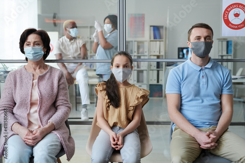 Row of mature woman, little girl and young man going to have vaccination