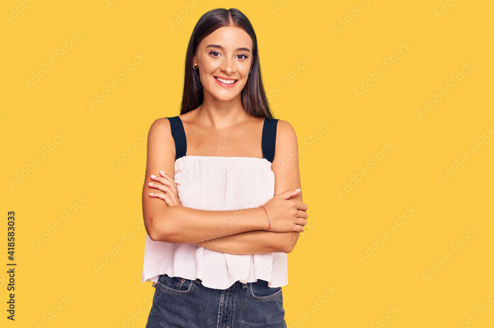 Young hispanic woman wearing casual clothes happy face smiling with crossed arms looking at the camera. positive person. Young hispanic woman wearing casual clothes happy face smiling with crossed arms looking at the camera. positive person.
