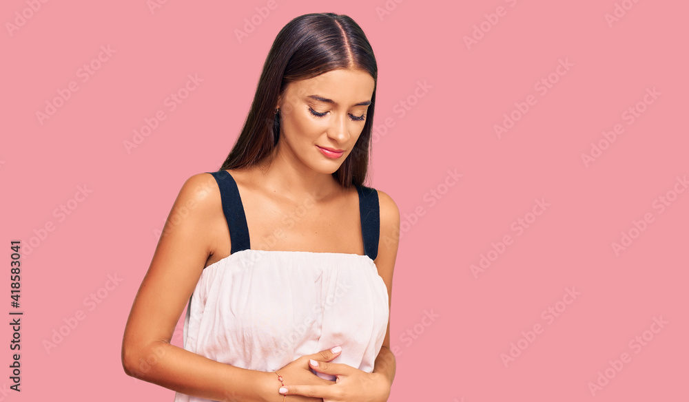 Young hispanic woman wearing casual clothes with hand on stomach because indigestion, painful illness feeling unwell. ache concept. Young hispanic woman wearing casual clothes with hand on stomach because indigestion, painful illness feeling unwell. ache concept.