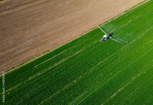 Aerial view of modern farm machine sprayer on green field. Modern technology of agriculture