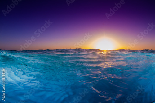 A shot of the sun rising over the Caribbean sea with the camera held very low to the water to catch the cool effect