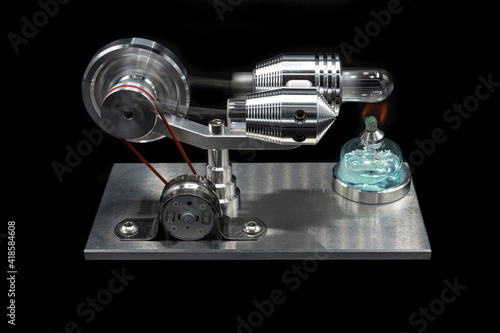 Stirling engine running on black background photo