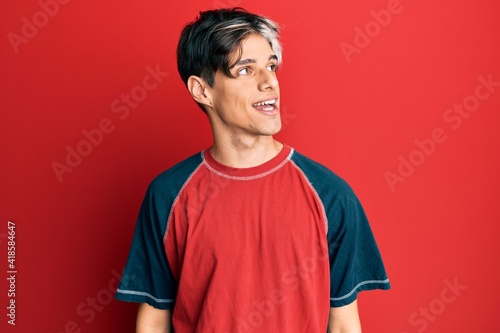 Young hispanic man wearing casual clothes looking to side, relax profile pose with natural face and confident smile.