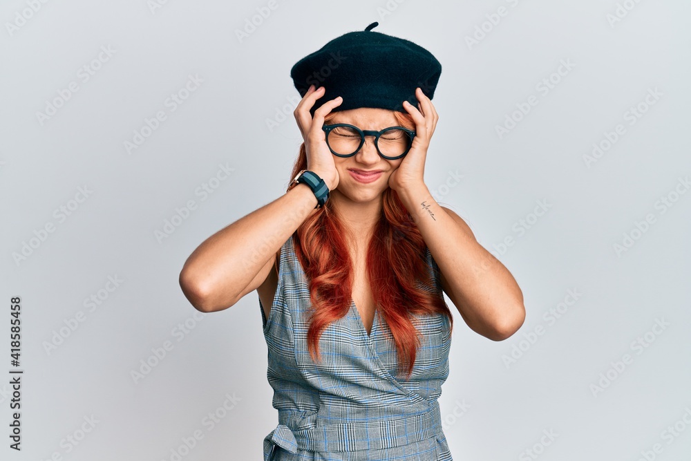 Young redhead woman wearing fashion french look with beret suffering from headache desperate and stressed because pain and migraine. hands on head. Young redhead woman wearing fashion french look with beret suffering from headache desperate and stressed because pain and migraine. hands on head.