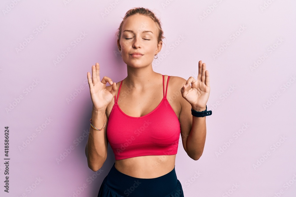 Beautiful caucasian woman wearing sportswear relax and smiling with eyes closed doing meditation gesture with fingers. yoga concept.