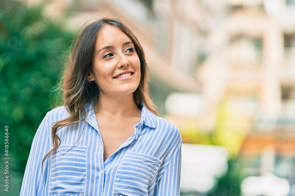 Young hispanic woman smiling happy standing at the city.