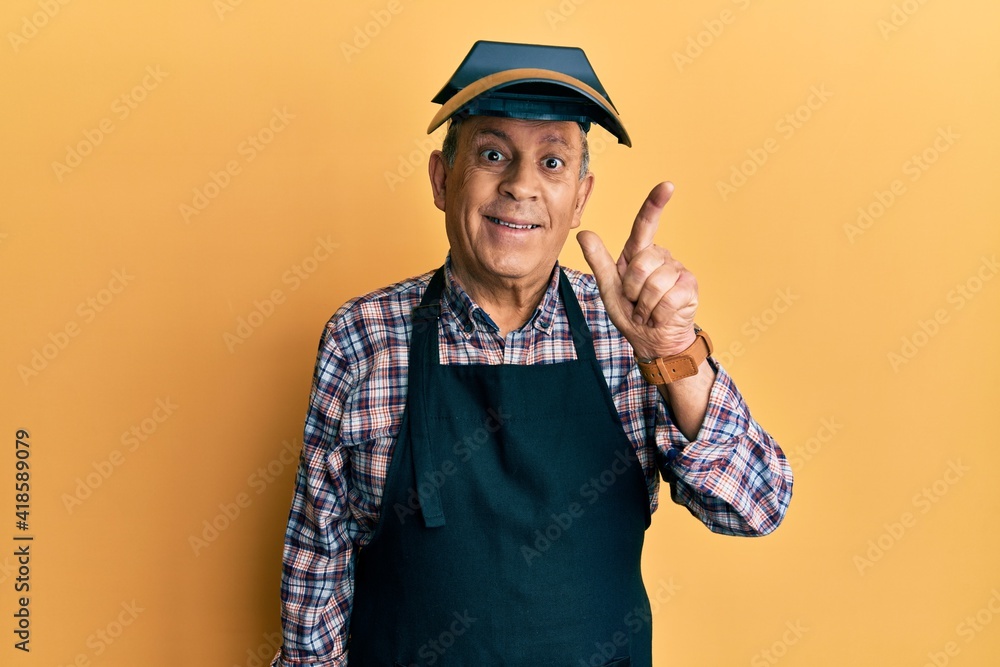Handsome senior man with grey hair wearing welding protection mask showing and pointing up with fingers number two while smiling confident and happy. Handsome senior man with grey hair wearing welding protection mask showing and pointing up with fingers number two while smiling confident and happy.