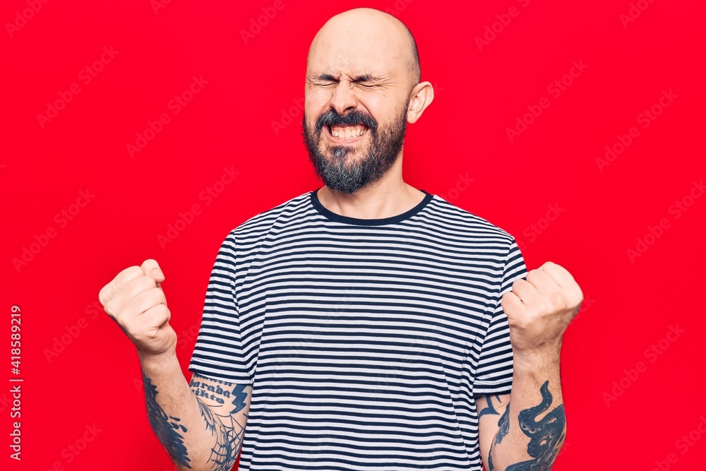 Naklejka premium Young handsome man wearing casual clothes very happy and excited doing winner gesture with arms raised, smiling and screaming for success. celebration concept.