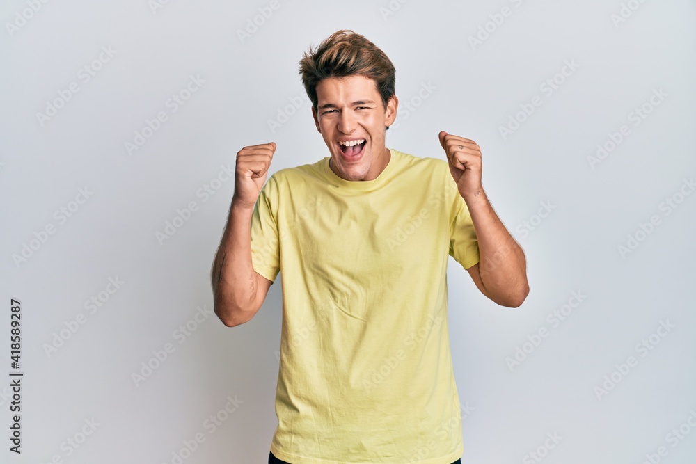 Handsome caucasian man wearing casual clothes celebrating surprised and amazed for success with arms raised and open eyes. winner concept. Handsome caucasian man wearing casual clothes celebrating surprised and amazed for success with arms raised and open eyes. winner concept.
