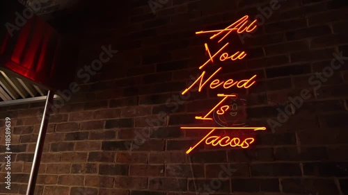 Funny orange neon light on red brick wall