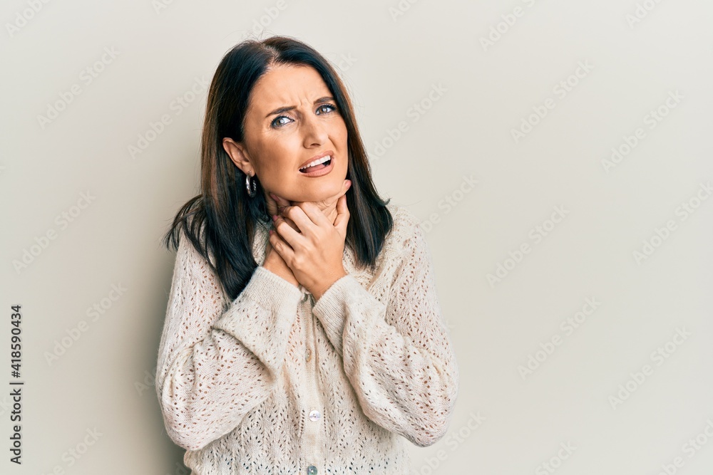 Middle age brunette woman wearing casual clothes shouting and suffocate because painful strangle. health problem. asphyxiate and suicide concept. Middle age brunette woman wearing casual clothes shouting and suffocate because painful strangle. health problem. asphyxiate and suicide concept.