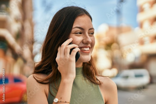 Young caucasian girl smiling happy talking on the smartphone at the city.