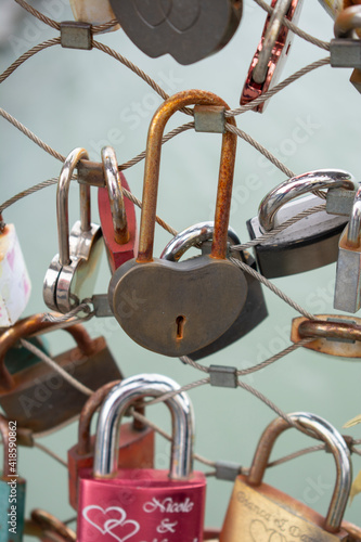 Love padlocks with heart shape. Concept of love. Metallic love padlock on a bridge full of padlocks.