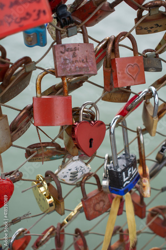 Love padlocks with heart shape.  Concept of love. Metallic  love padlock on a bridge full of padlocks. © Stefan