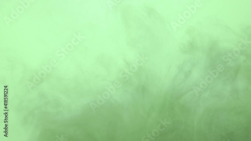 Dark ink spreading in green-blue water. Abstract color background, liquid smoke effect, psychedelic and art concept.