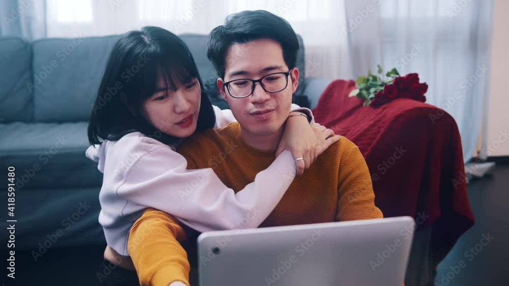 Happy young couple relaxing on the couch hugging and watching movie on the laptop. High quality 4k footage Happy young couple relaxing on the couch hugging and watching movie on the laptop. High quality 4k footage