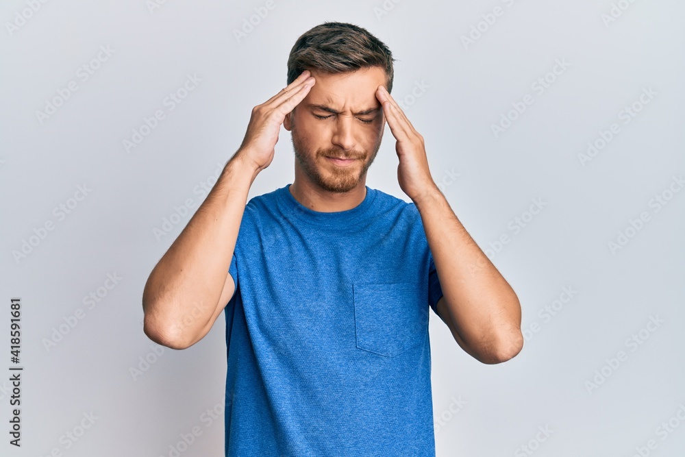 Handsome caucasian man wearing casual clothes with hand on head, headache because stress. suffering migraine. Handsome caucasian man wearing casual clothes with hand on head, headache because stress. suffering migraine.