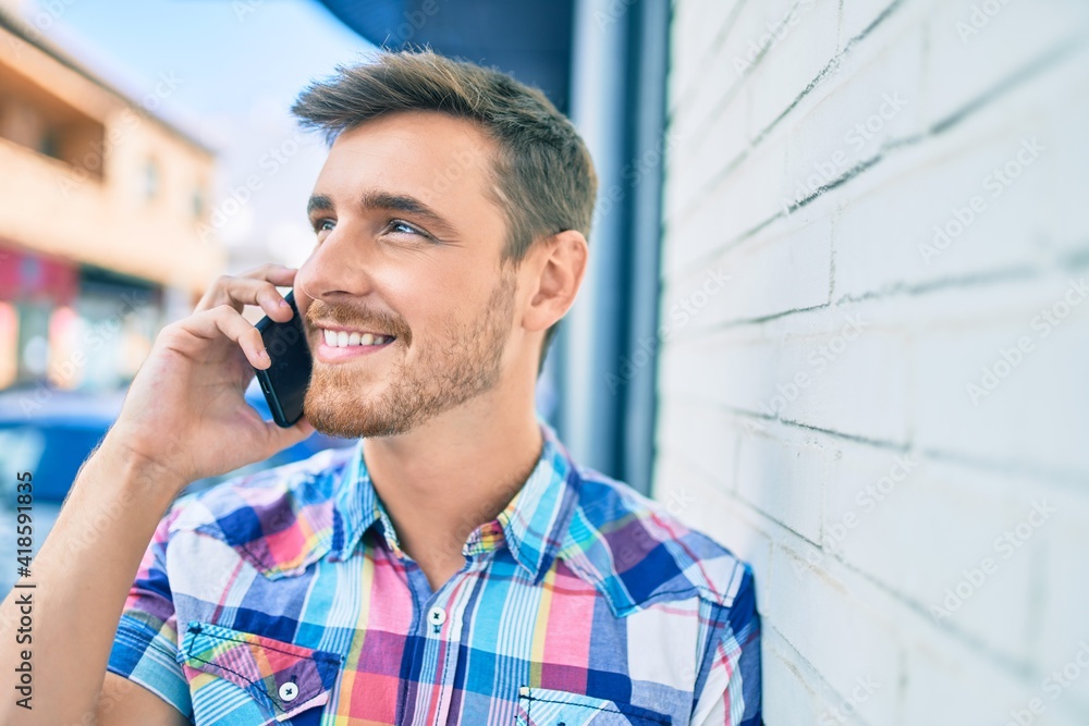 Young caucasian man smiling happy talking on the smartphone at the city. Young caucasian man smiling happy talking on the smartphone at the city.