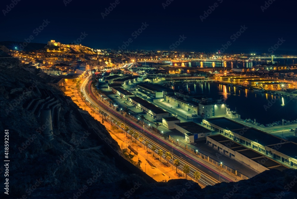 Vista nocturna de la Alcazaba, puerto y ciudad de Almeria. Luces de la ciudad. Estelas de luz