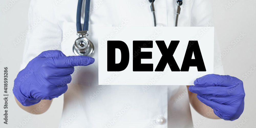 The doctor points his finger at a sign that says - DEXA The doctor points his finger at a sign that says - DEXA