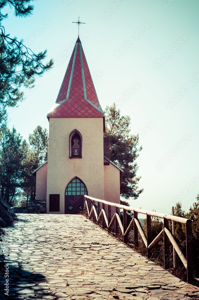 Vista frontal de la ermita de un pueblo minero de montaña. La ermita está dedicada a Santa Bárbara, patrona de los mineros. Estilo colonial, con clara inspiración centroeuropea