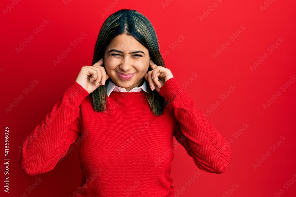 Young latin woman wearing casual clothes covering ears with fingers with annoyed expression for the noise of loud music. deaf concept. Young latin woman wearing casual clothes covering ears with fingers with annoyed expression for the noise of loud music. deaf concept.