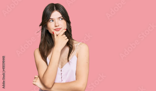 Young beautiful caucasian girl wearing casual clothes with hand on chin thinking about question, pensive expression. smiling with thoughtful face. doubt concept.